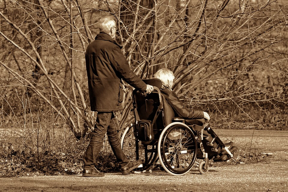 Starija osoba gura kolica invalida