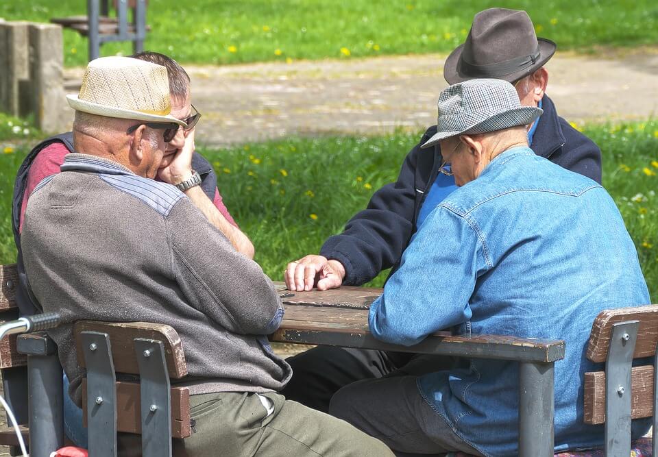 Umirovljenici kartaju u parku.