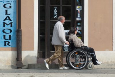Muškarac gura ženu u invalidskim kolicima
