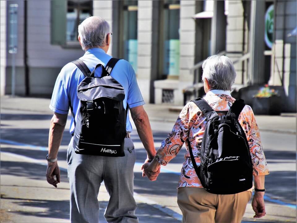 Stariji bračni par s ruksacima na leđima na izletu