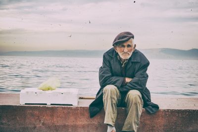 Stariji gospodin sjedi na obali