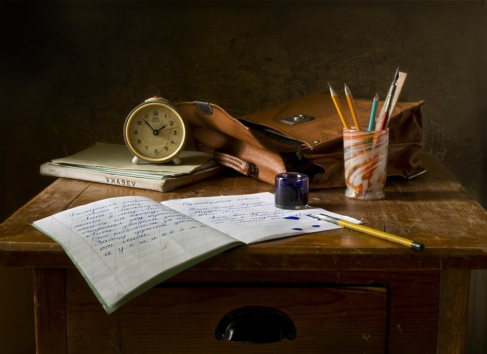 Pisanje pisma na stolu, uz bojice u čaši