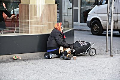 Beskućnica sjedi na ulici