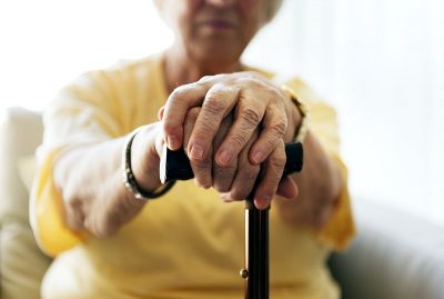 Starija ženska osoba sa štapom u rukama