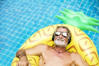 umirovljenik sa sunčanim naočalama na žutom madracu na napuhavanje