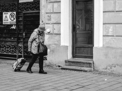 Starija ženska osoba vuče za sobom torbu