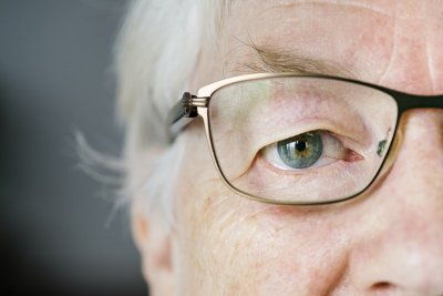 Pola lica umirovljenice koja na olima ima naočale