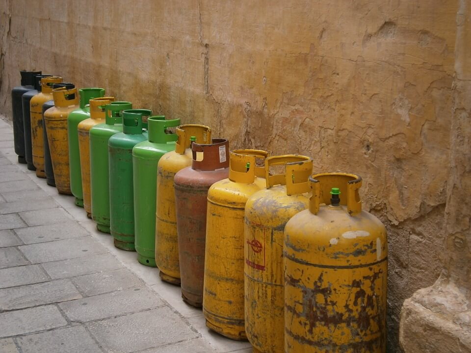 Plinske boce različitih boja koje stoje uza zid