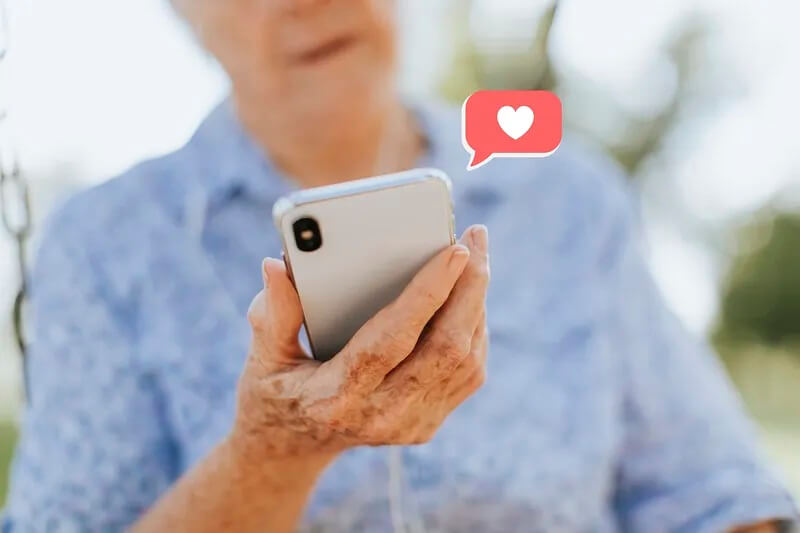 Starija osoba gleda u mobitel