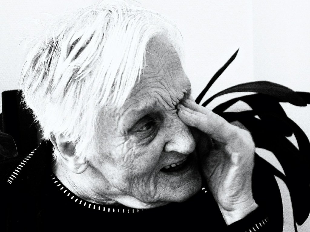 Starija gospođa na crno-bijeloj fotografiji briše suze jednom rukom