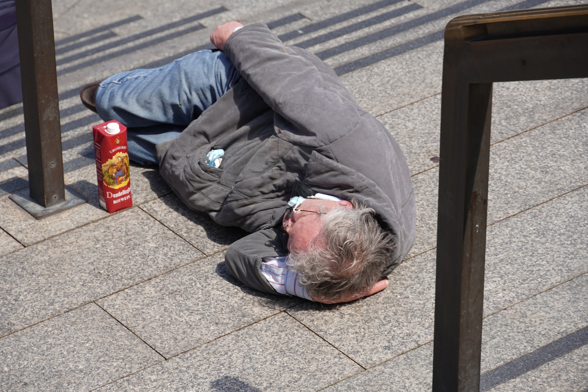 Muškarac beskućnik leži na podu