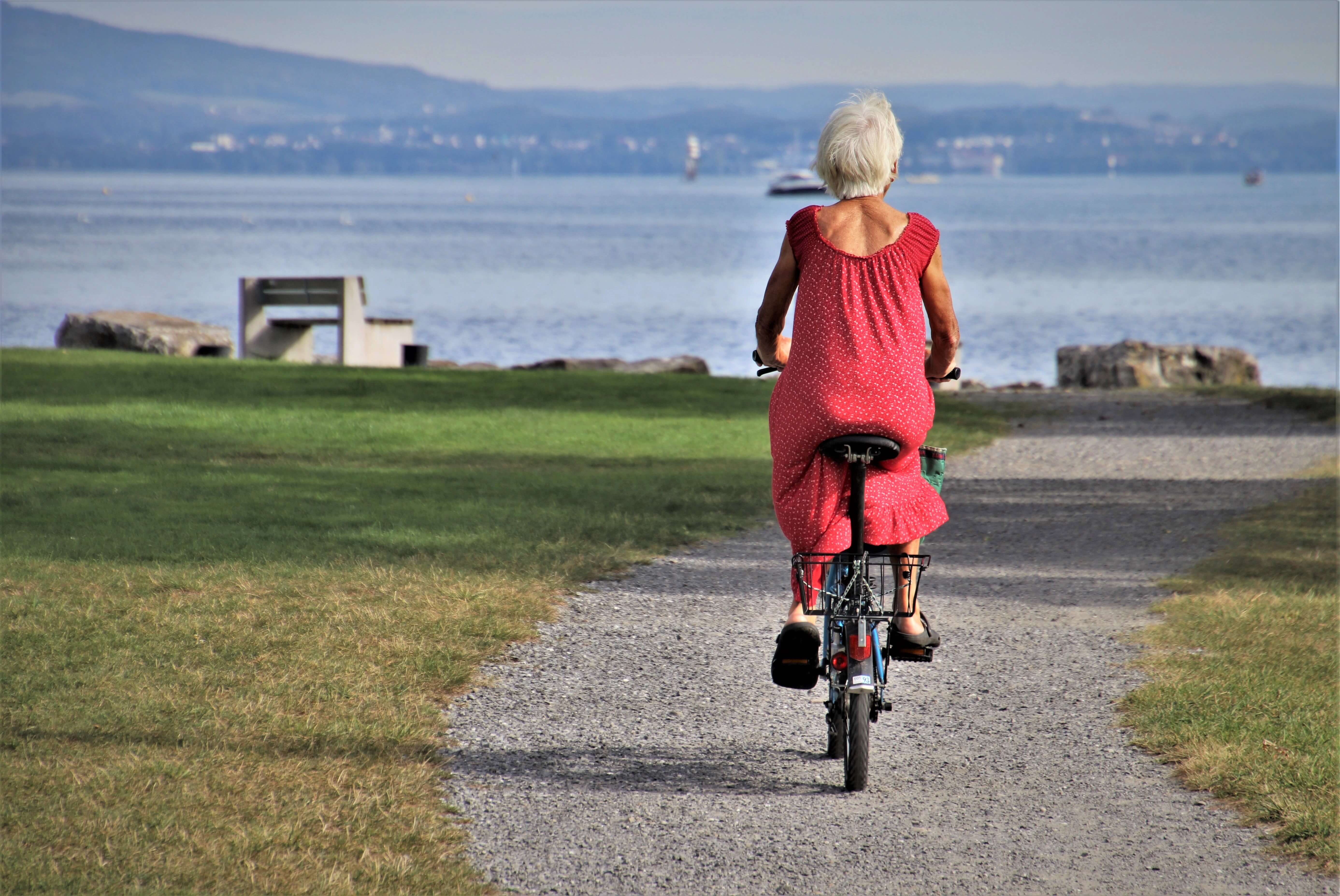 Umirovljenica u crvenoj haljini na biciklu