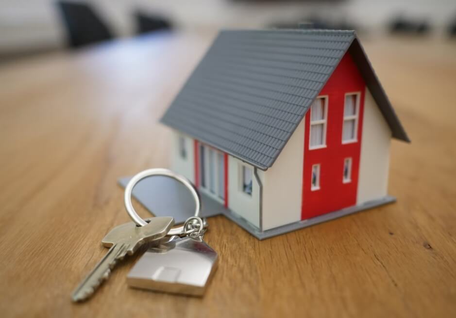 Mala maketa kuće i ključ pored nje