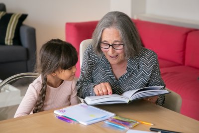 Starija ženska osoba čita djevojčici