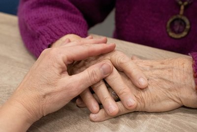 Ruka mlađe osobe na rukama starije osobe