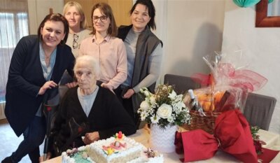 Baka Smiljana slavi svoj 104. rođendan s tortom i cvijećem ispred sebe, u društvu zaposlenica projekta Zaželi