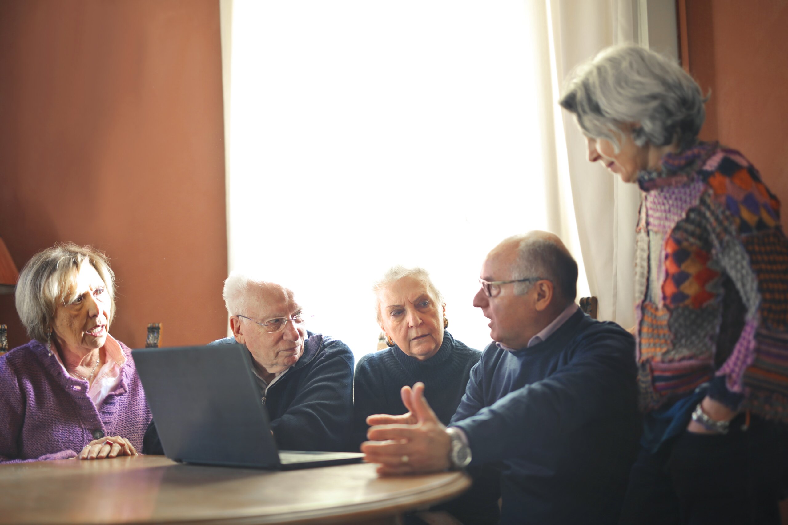 Umirovljenici sjede za stolom i razgovaraju