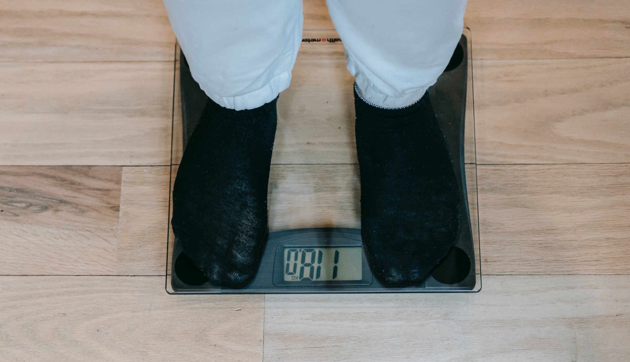 Čovjek stoji na digitalnoj vagi koja pokazuje 118 kilograma