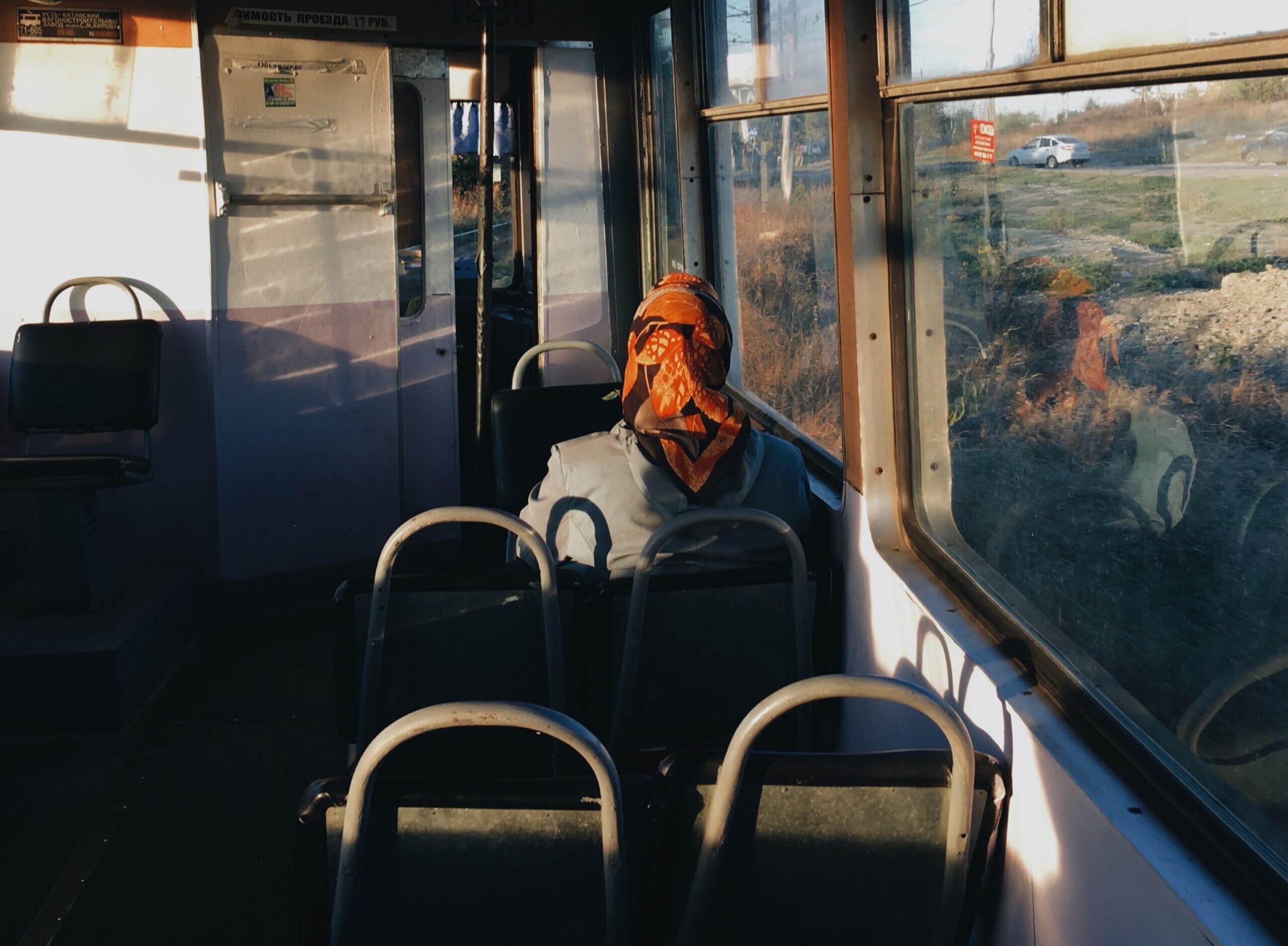 Starija žena s rupcem na glavi sama u autobusu