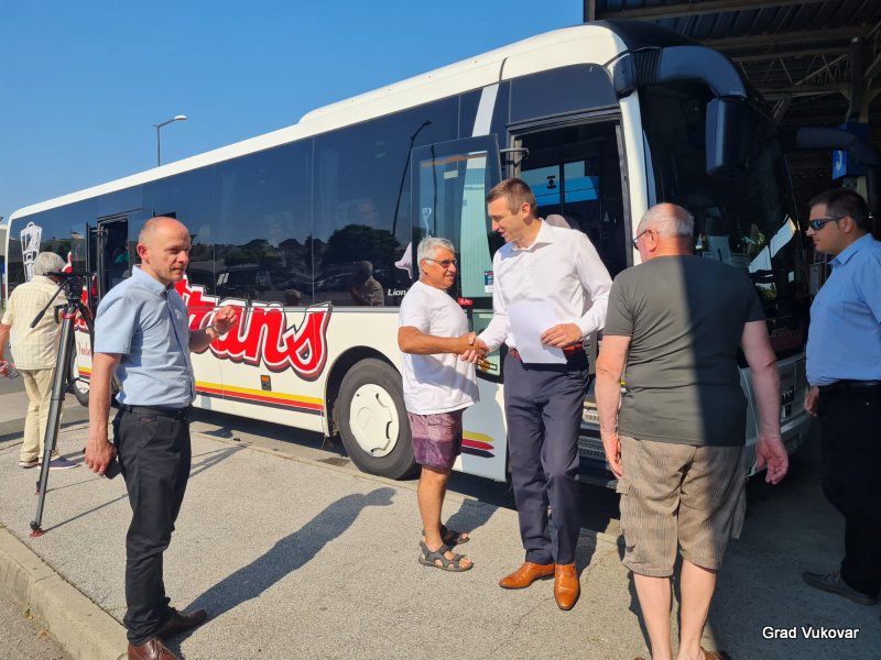 Umirovljenici stoje ispred autobusa koji ih vozi na izlet u Bizovačke toplice
