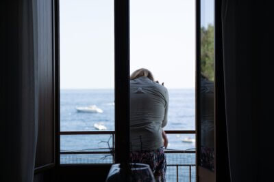 Umirovljenica na balkonu apartmana na moru gleda prema dolje