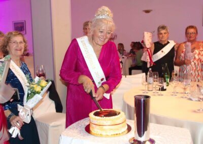 Miss umirovljenika u ružičastoj haljini reže tortu na izboru za Miss umirovljenika