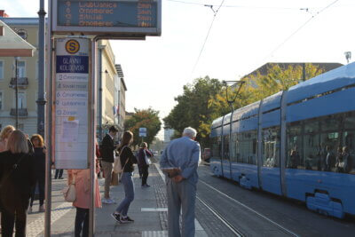 tramvajska stanica s ljudima koji čekaju tramvaj