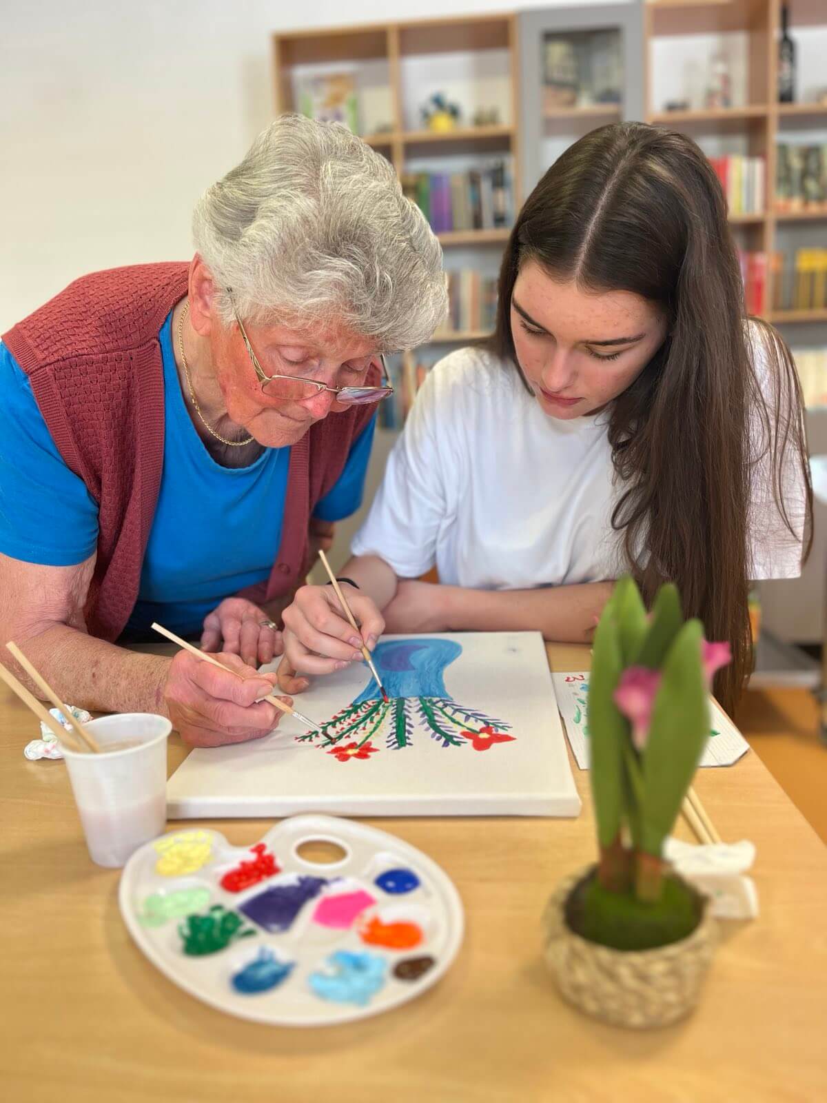 Umirovljenica i učenica crtaju cvijeće vodenim bojicama