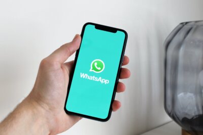 Ruka drži mobitel na kojem je otvorena aplikacija WhatsApp