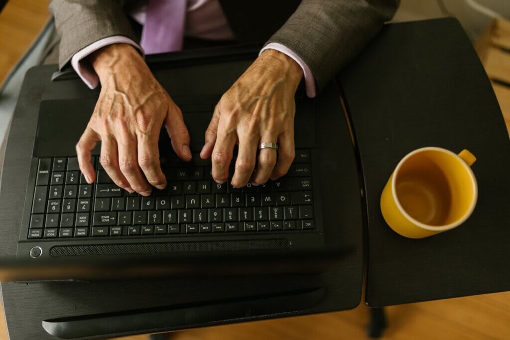 Umirovljenik tipka na laptopu; tipkovnica
