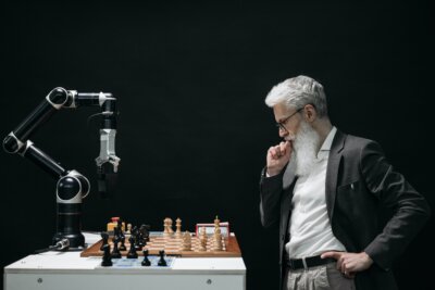 Stariji muškarac igra šah s robotskom rukom