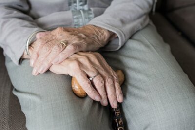 Starija osoba sa štapom u rukama