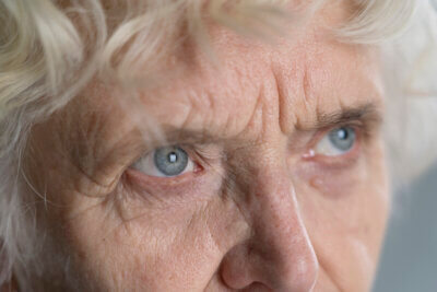 Umirovljenica sijede kose i plavih očiju.