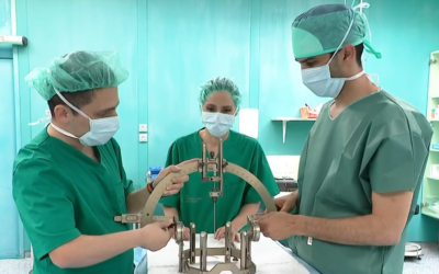 Tim kirurga u zelenim kutama drže metalni uređaj
